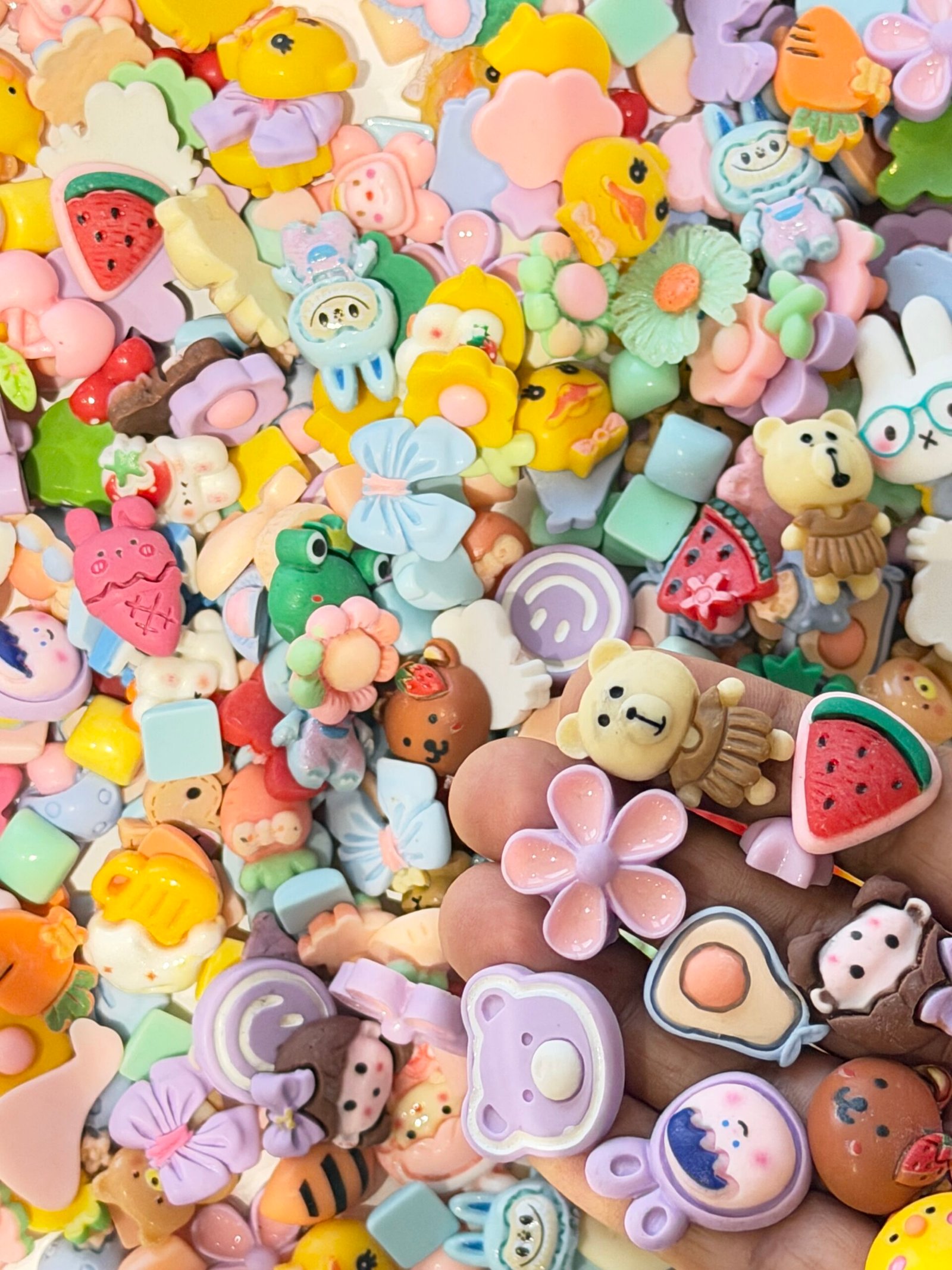 A colorful pile of mixed pastel resin charms including teddy bears, watermelon slices, lavender flowers, and yellow ducks for decoden crafting. Decoden Charms, Resin Cabochons, Kawaii DIY Supplies, Flatback Charms, phone case decoration, scrapbooking charms, pastel craft supplies, miniature food charms, 3D resin art