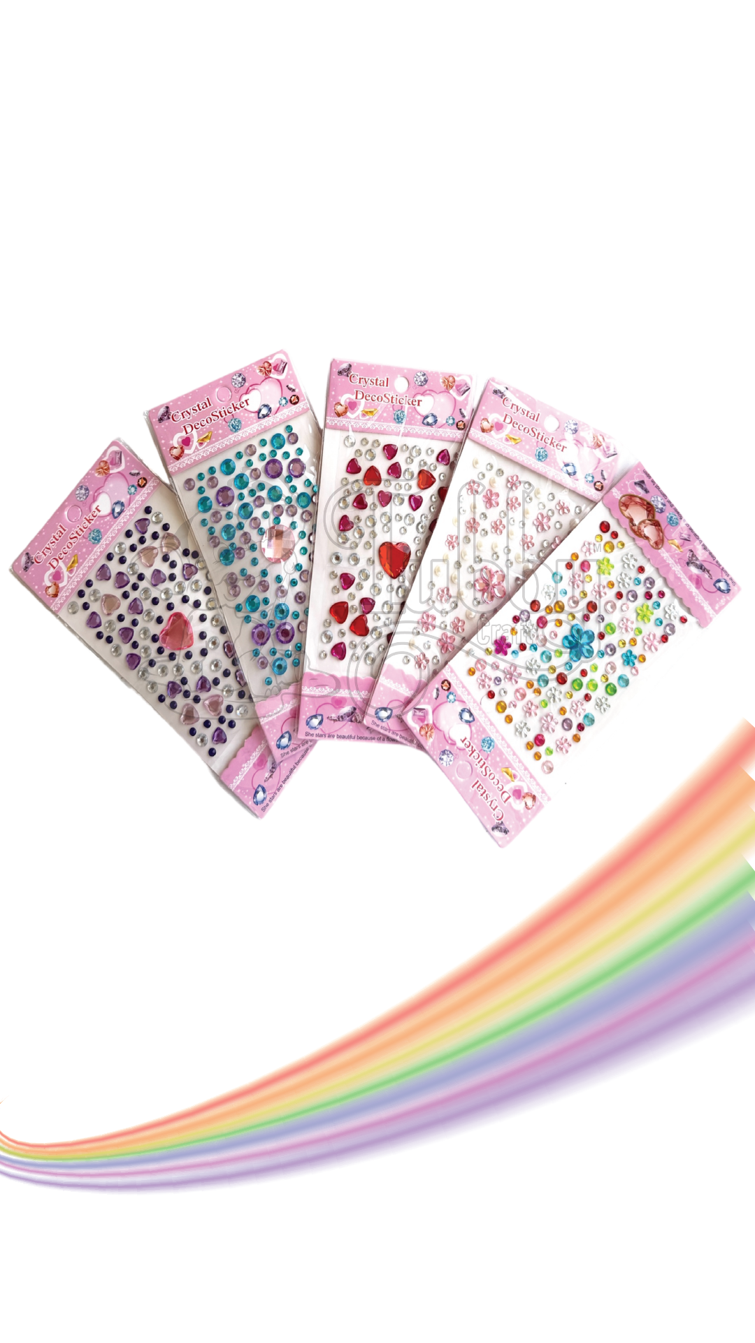 Five vertical packs of individual "Crystal DecoSticker" sets fanned out in a dynamic arc. The clear, adhesive-backed sheets showcase a beautiful assortment of 3D gems, hearts, and flower shapes in a vibrant range of colors—including sapphire blue, rose pink, magenta, clear crystal, emerald green, and a multi-colored floral mix. They are presented on light pink cardstock with a pink lace border and sweet illustrations, all set against a clean white background with a colorful, pastel rainbow swirl moving beneath.